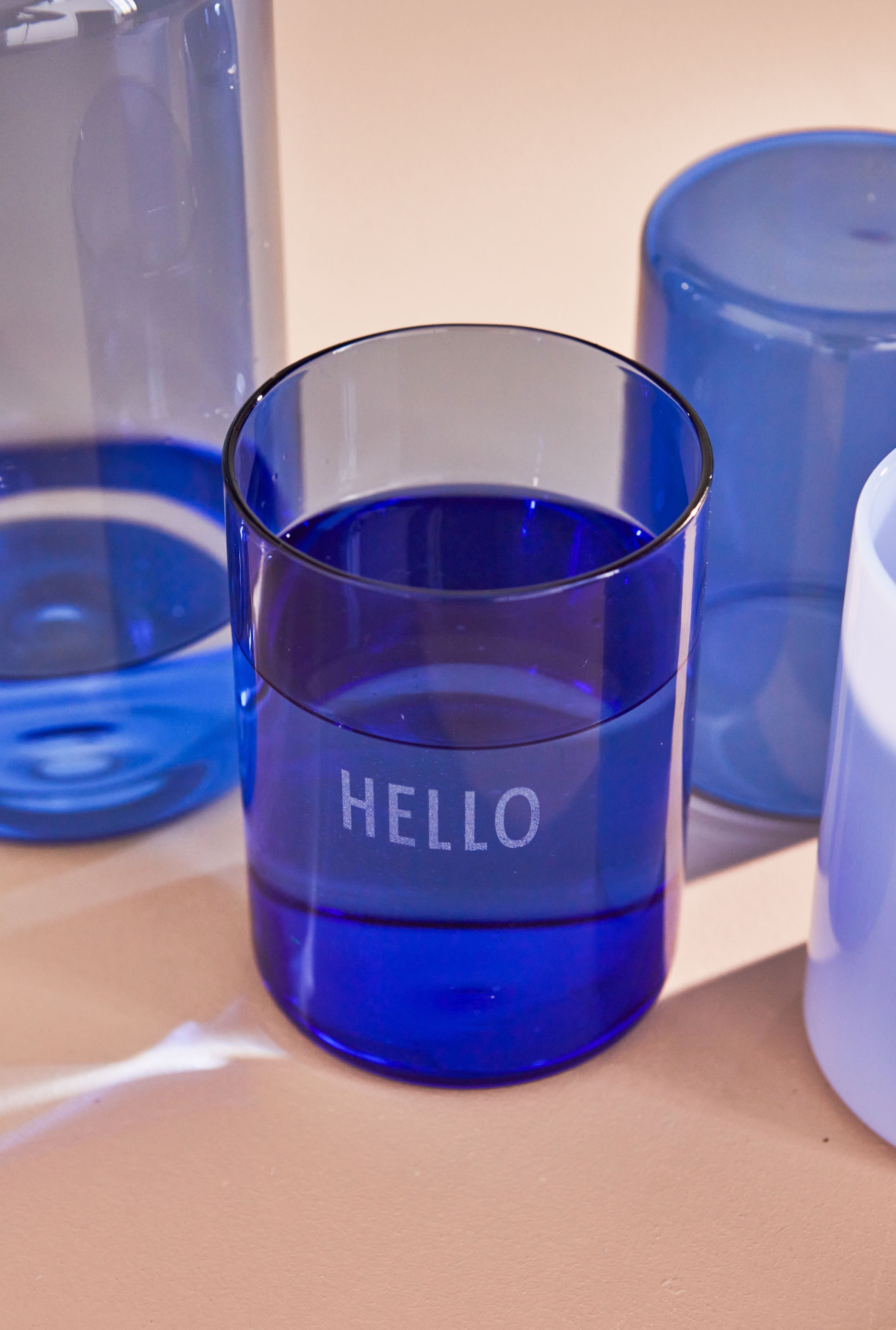 Il vetro da bere preferito della lettera di design ciao, blu