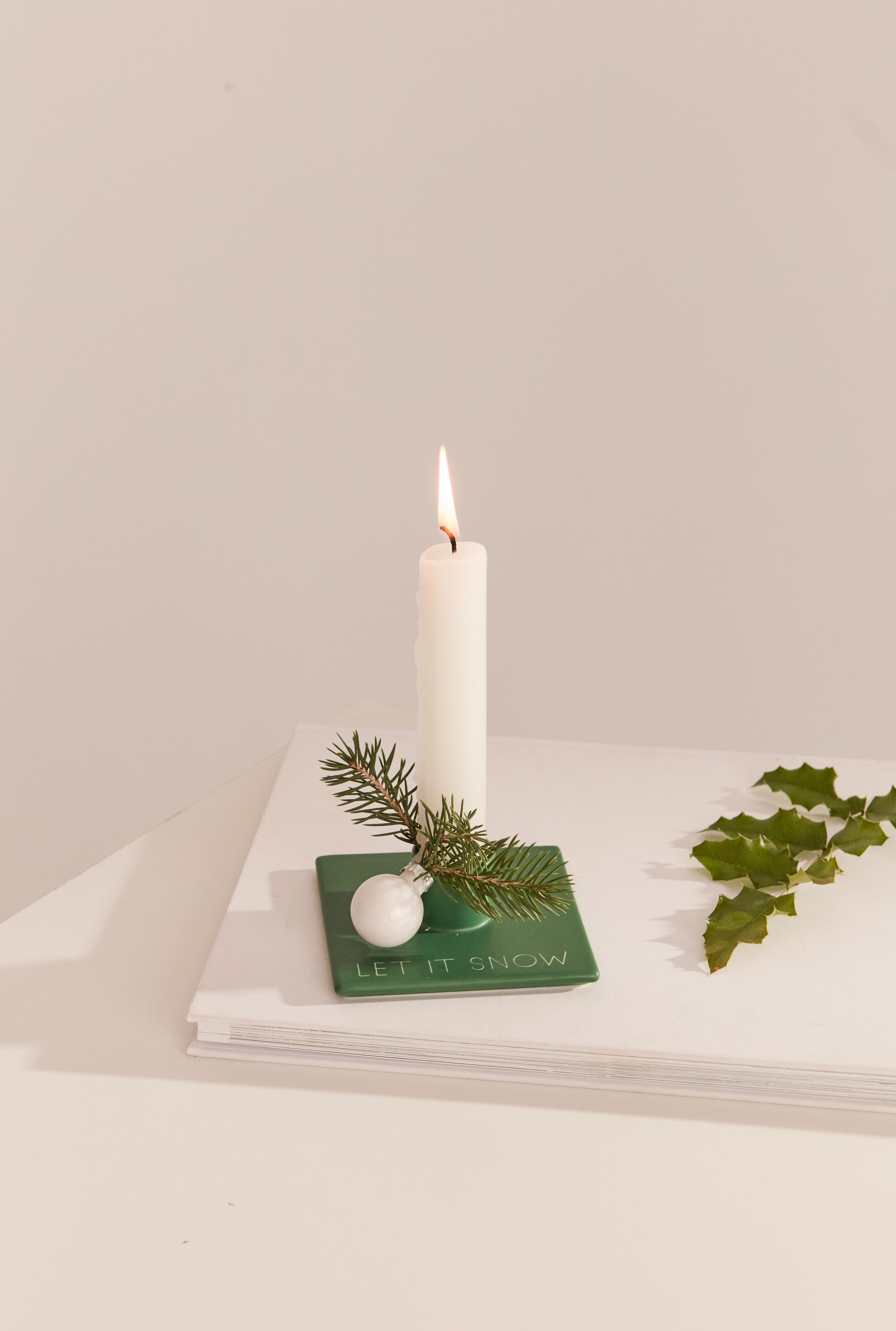 设计信圣诞节蜡烛握住它，让它下雪，草绿